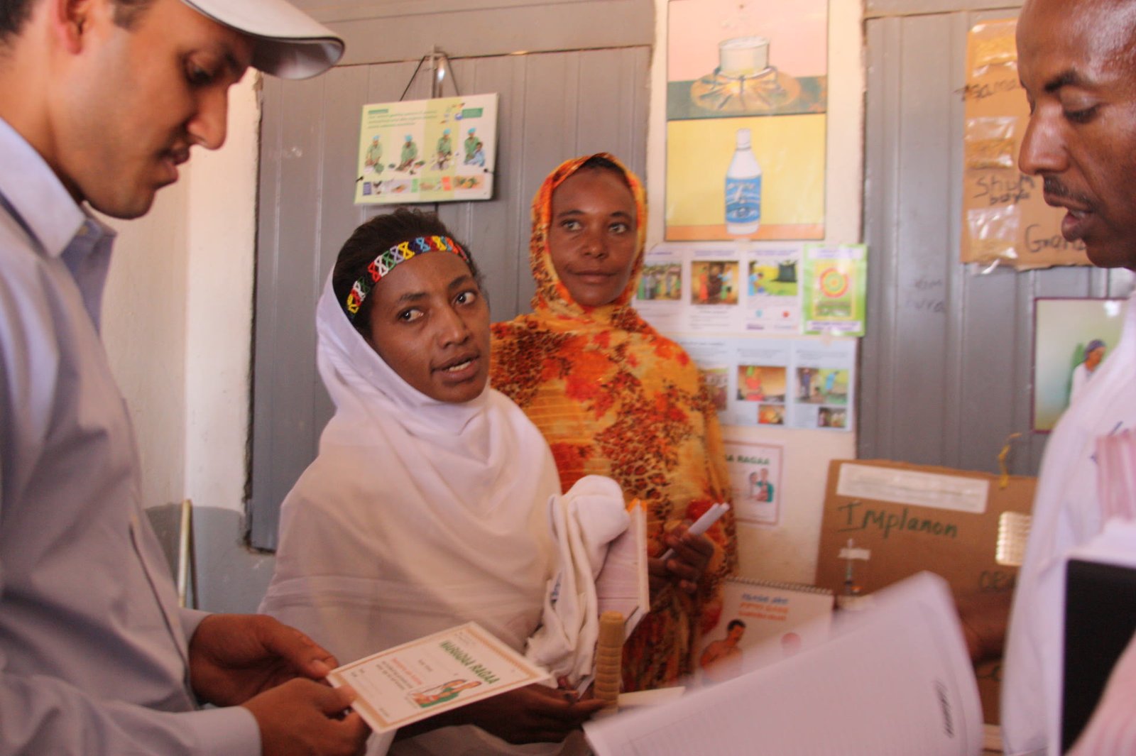 A community health worker reviewing care records with families at a local clinic